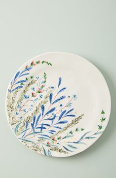 a white plate with blue and green designs on the rim, against a gray background