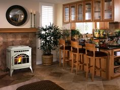 a kitchen with a wood stove and dining room table in front of the fire place