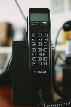 an old style phone sitting on top of a wooden table