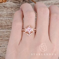 a woman's hand with a pink diamond ring on top of her left hand