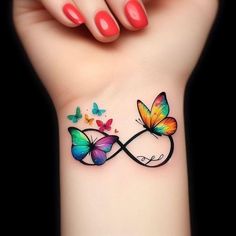 a woman's wrist with two butterflies on it and the word love written in butterfly tattoos