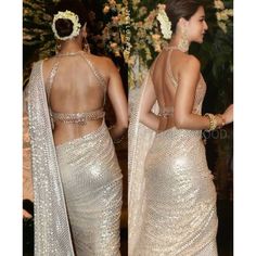 two women dressed in sari and headpieces, one is wearing an open back dress