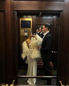 a man and woman standing in front of an elevator