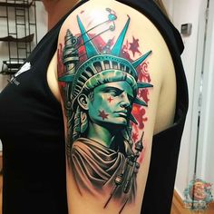 a lady liberty tattoo on the back of a woman's shoulder