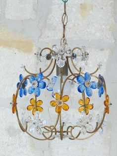 a chandelier with blue and yellow flowers hanging from it