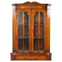 an old fashioned wooden china cabinet with glass doors on the front and bottom shelves,