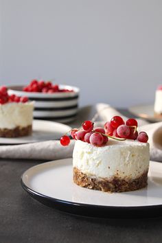 there is a piece of cheesecake with berries on top and other desserts in the background