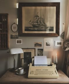 an old fashioned typewriter sitting on top of a wooden desk next to a lamp