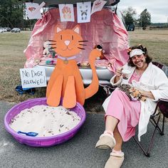 a woman sitting in a chair next to a cat statue