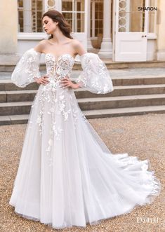 a woman in a white wedding dress standing outside