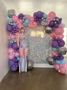 a woman standing in front of a balloon arch