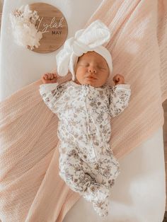 a baby laying on top of a white blanket