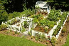 an aerial view of a garden with white picket fence