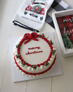 a decorated christmas cake sitting on top of a table next to a box and napkin