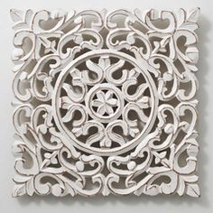 an intricately designed wall panel on a white wall in the shape of a circle