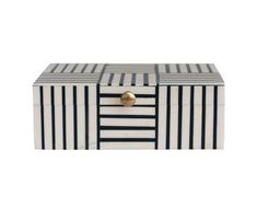 a black and white striped box with gold knobs on the lid, sitting against a white background