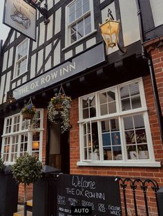 the ox row inn is located on an old brick building with white windows and black trim