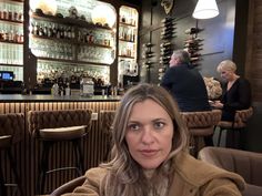 a woman sitting at a table in front of a bar