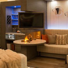 a living room filled with furniture and a flat screen tv mounted on the wall above a fire place