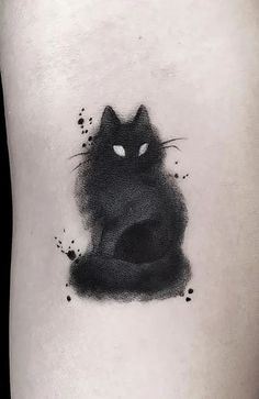 a black cat tattoo on the left thigh