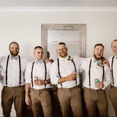 a group of men standing next to each other wearing brown suspenders and bow ties