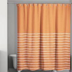 an orange and white shower curtain hanging on a bathroom wall next to a bathtub