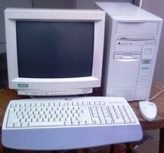 an old desktop computer sitting on top of a table next to a keyboard and mouse