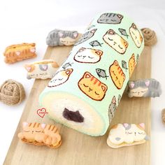 a roll with cats on it sitting on top of a cutting board next to small toy animals