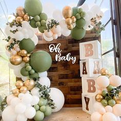 a baby shower with balloons and greenery