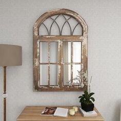 an old wooden table with a mirror on the wall above it and a lamp next to it