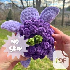 there is a purple flower that has been crocheted into the shape of a butterfly