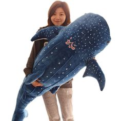 a woman is holding a stuffed whale