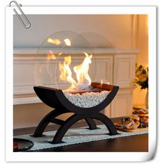 a fire pit sitting on top of a wooden table next to a white rug and fireplace