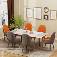 a dining room table with orange chairs and a white marble top in front of a window