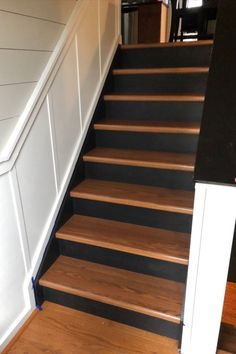 the stairs are painted black and white with wood treads