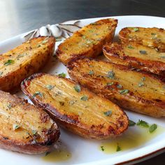 grilled potatoes with herbs on a white plate