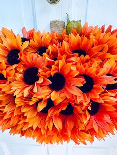 a bunch of orange flowers are hanging from the ceiling in front of a white door