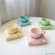 three cups and saucers sitting on top of a white table