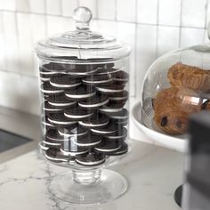 there are cookies and croissants in the glass container on the kitchen counter