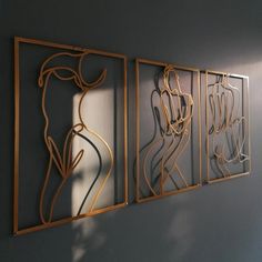 three metal art pieces hanging on the wall