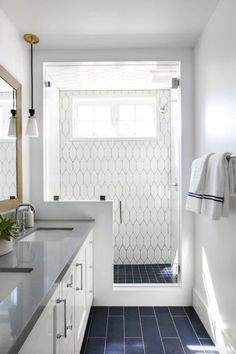 a bathroom with blue and white tile flooring next to a walk - in shower