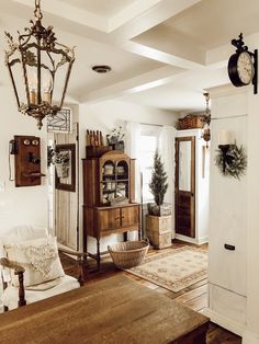 a living room filled with furniture and a clock on the wall above it's doorway