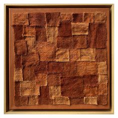 a brown and tan wall hanging on the side of a wooden framed artwork piece with squares in it