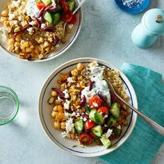 two bowls filled with different types of food on top of a white tablecloth and blue napkins