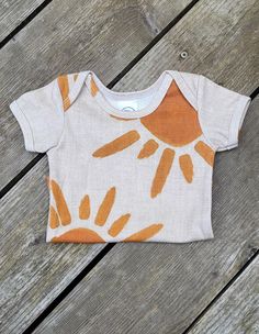 Suns Short Sleeve Onesie Soft Organic Cotton baby onesie with Sun silhouettes on a natural background. Made by Bootyland's in-house brand Baby Nesh Organics. Made in Oregon, USA. Materials: GOTS Certified Organic Cotton. Onesie Design Ideas, Painted Onesies, Onesie Decorating, Onesie Ideas, Trendy Baby Onesies, Pretend Play Costumes, Baby Onsie, Box Costumes, Hobby Ideas