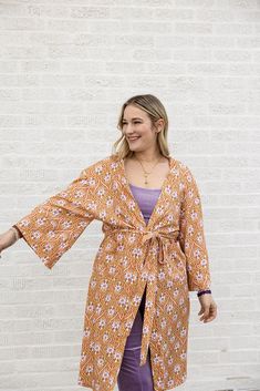 make a statement in the greta cardi duster! this midi-length duster is designed with a removable tie, and pockets for added convenience and style. this style of cardi duster is perfect to pair over our misty dress in stay groovy daisy or with the matching estelle pant and jazz tank for a retro vibe. Spring Floral Print Outerwear For Loungewear, Fitted Open Front Robe For Spring, Open Front Robe For Daywear In Spring, Oversized Open Front Spring Robe, Spring Floral Print Fitted Robe, Fitted Floral Print Spring Robe, Fitted Floral Print Robe For Spring, Casual Open Front Spring Robe, Groovy Daisy