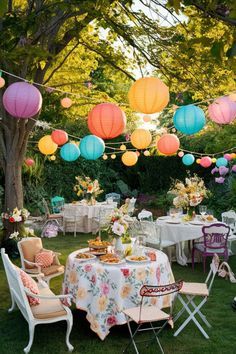 an outdoor party with paper lanterns and tables