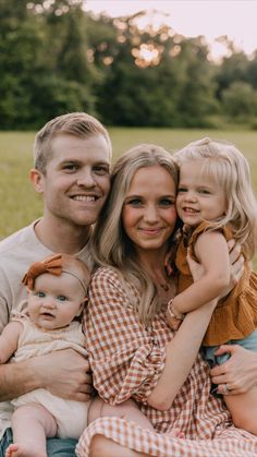 a man and woman holding two small children