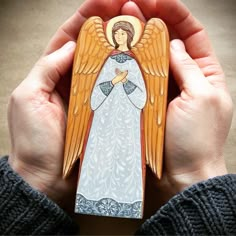 a person holding an angel card in their hands