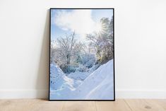 a framed photograph sitting on top of a wooden floor in front of a white wall